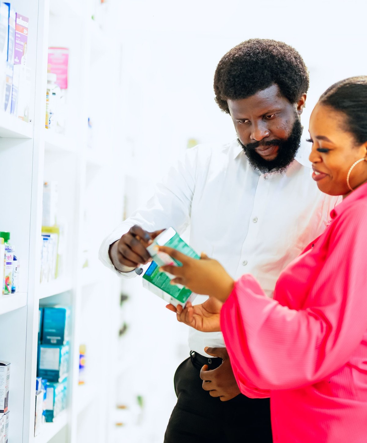 Un pharmacien conseille une cliente dans une officine en Afrique