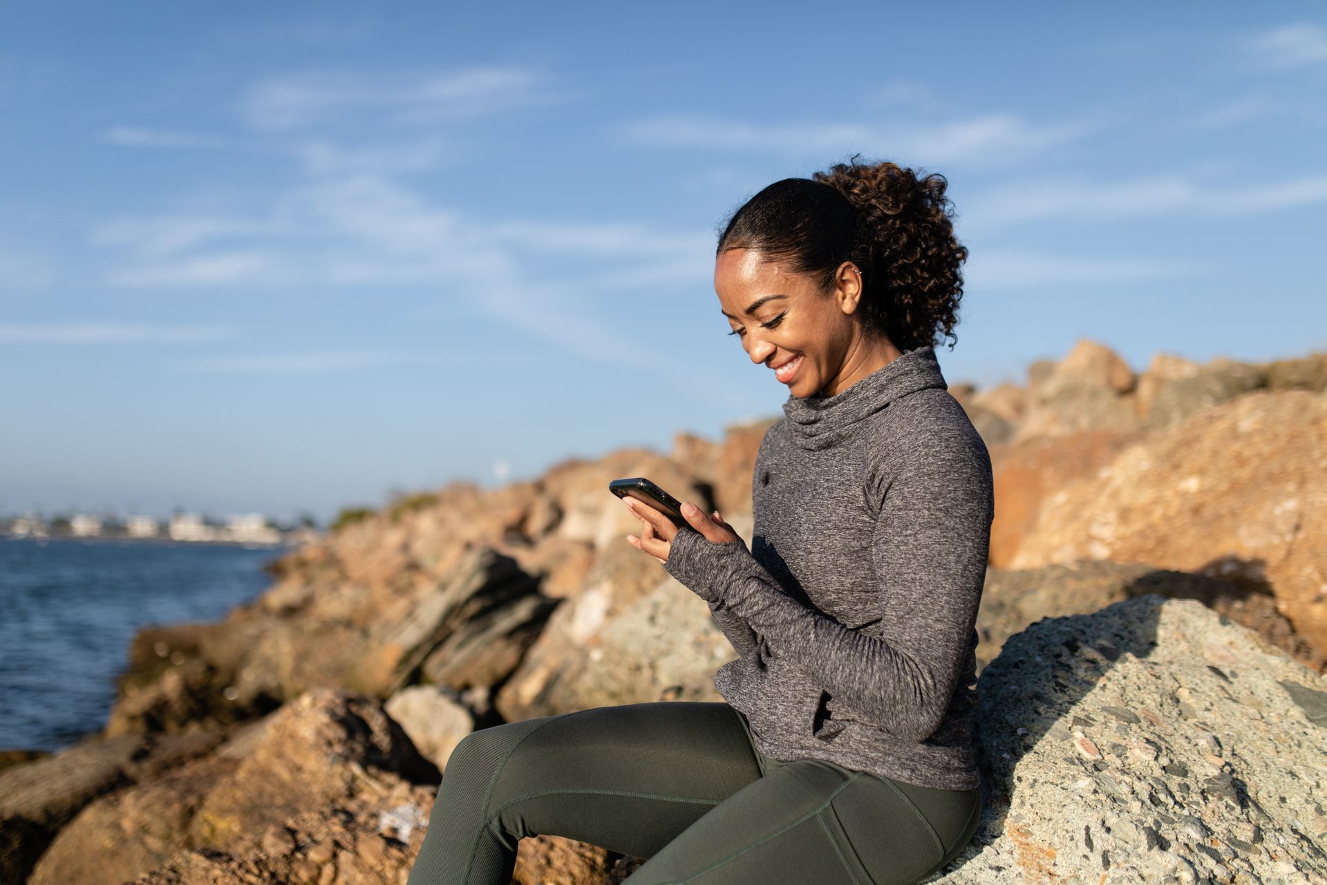 Une patiente sourit en consultant sa santé depuis son téléphone